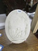 An oval plaque with classical cherub scene.