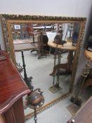 A large gilt framed bevel edged mirror.