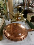 A brass kettle on brass trivet and a copper warming pan.
