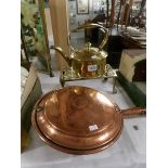 A brass kettle on brass trivet and a copper warming pan.