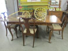 A walnut extending dining table with protective glass top and 4 matching chairs.