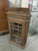 A carved oak corner cabinet.