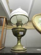A brass oil lamp with white shade.