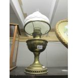 A brass oil lamp with white shade.