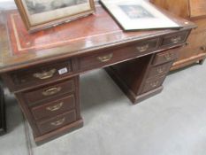 A kneehole desk with leather inset top.