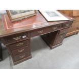 A kneehole desk with leather inset top.