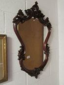 A shield shaped carved mahogany framed mirror,.