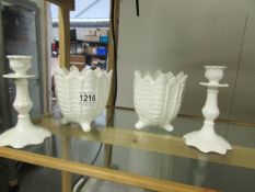 A pair of Coalport white plant pots and a pair of Coalport white candlesticks.