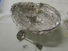 An ornate silver plated basket and a ladle.