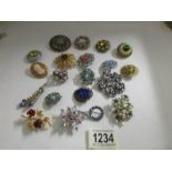 19 assorted costume brooches and a scarf clip.