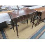 A mahogany fold over games table on reeded legs.