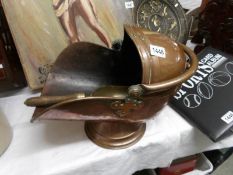 A copper coal scuttle with scoop.