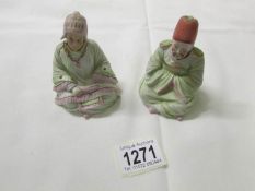 A pair of 19th century bisque porcelain nodding head figures.
