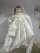 A porcelain 3 faced doll in original clothing.