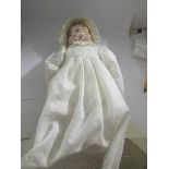 A porcelain 3 faced doll in original clothing.