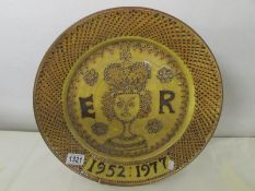 A large pottery charger commemorating the Silver Jubilee of Queen elizabeth II in a medieval style
