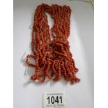 A vintage 10 strand long coral necklace with coral tassel.