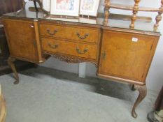 A walnut sideboard with protective glass top.