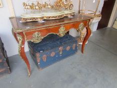A French style ormolu mounted desk with leather inset top and three drawers.