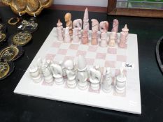 A carved soapstone chess board & pieces