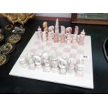 A carved soapstone chess board & pieces