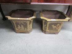 A pair of pottery planters with various floral and nature depictions.