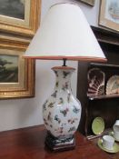 A ceramic table lamp decorated with butterflies.