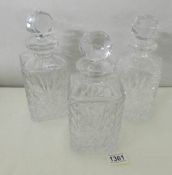 A set of 3 square cut glass decanters.