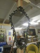 A metal framed shield shaped mirror.