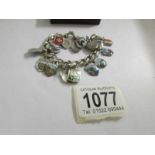 A silver bracelet with 19 enamel continental towns and cities shields with silver safety chain and