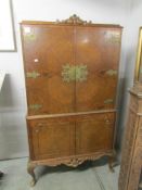 A walnut cocktail cabinet with brass mounts.