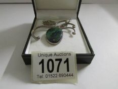 An unusual vintage turquoise set pendant with textured silver mount on a long silver chain.