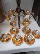 A gilded coffee set with classical scene cameos.