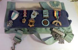 A collection of Masonic medals including 2 hall marked silver and a Masonic apron.