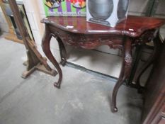 A carved mahogany console table.