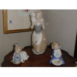 A large NAO figure of girl with lamb and a pair of NAO breakfast time figures,