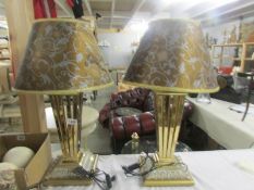 A pair of gilded table lamps with shades.