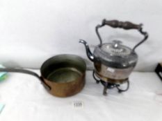 A kettle on stand with burner and a copper saucepan.