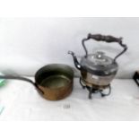 A kettle on stand with burner and a copper saucepan.