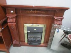 A carved and inlaid fire surround with inset fire.
