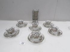 12 glass coffee cups and saucers with white metal decoration.