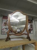 A shield shaped vanity mirror.