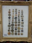 A collection of Lucy Rie pottery buttons in gilt frame.