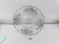 A glass plate with silver decoration.