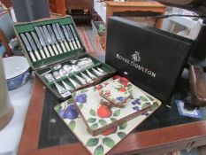 A Royal Doulton canteen of cutlery and a quantity of place mats.