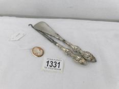 A silver handled shoe horn and button hook together with a cameo brooch.