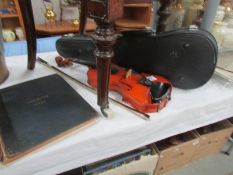 A cased violin with bow and a Beethoven music book.