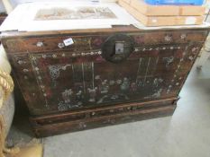 An antique chest with oriental scene to front.