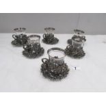 A set of 6 glass coffee cups with metal decoration and metal saucers.