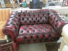 A burgundy leather 2 seat sofa.